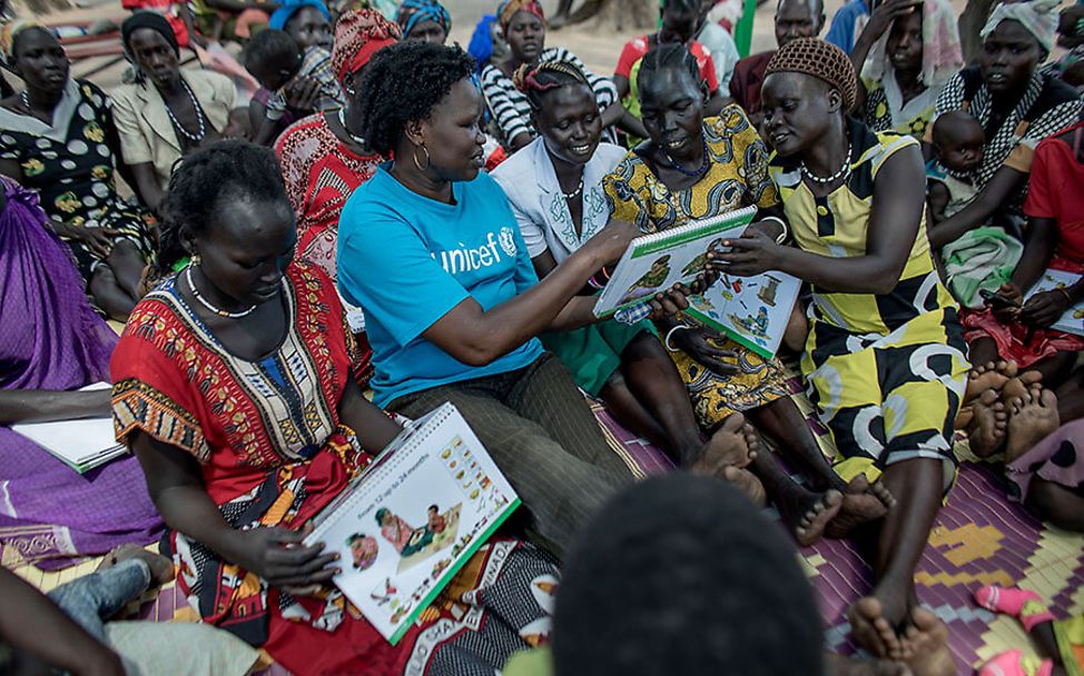 Südsudan: Ernährungsexpertin Jane Gune Rombe sitzt in einer Runde mit den Müttern in Tharkueng.
