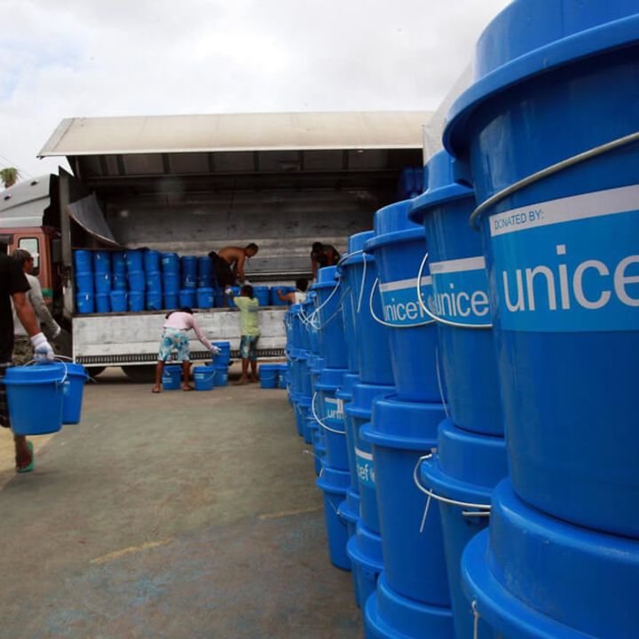 Philippinen: UNICEF-Hilfe nach Taifun. Ein Helfer trägt Tonnen mit Hilfsgütern