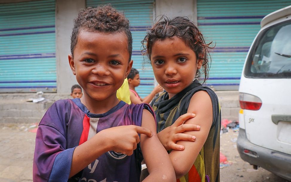 Jemen 2019: Ein Junge und ein Mädchen zeigen stolz auf die Stelle, wo sie geimpft wurden.