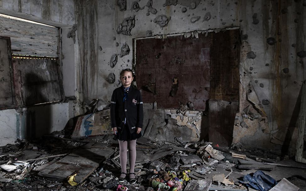 Ukraine: Ein Mädchen steht in einem zerstörten Kindergarten
