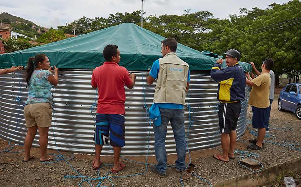 Venezuela: UNICEF-Mitarbeiter und Helfer stellen einen Tank für Trinkwasser auf