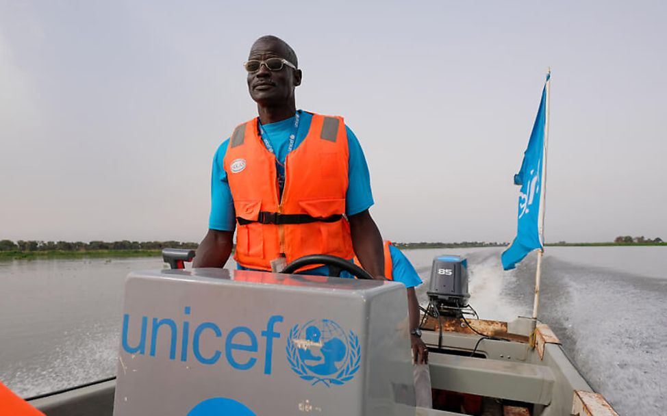 Südsudan: Ein UNICEF-Mitarbeiter transportiert Hilfsgüter per Boot