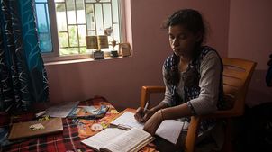 Indien: Kusma sitzt zuhause an ihren Schulaufgaben.