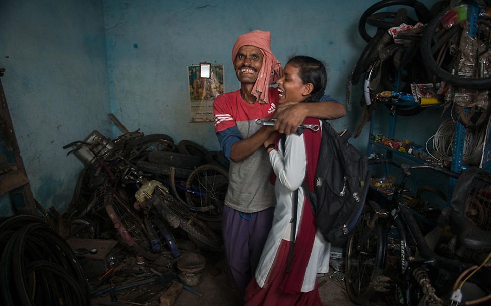Indien: Kusma und ihr Vater umarmen sich lachend.