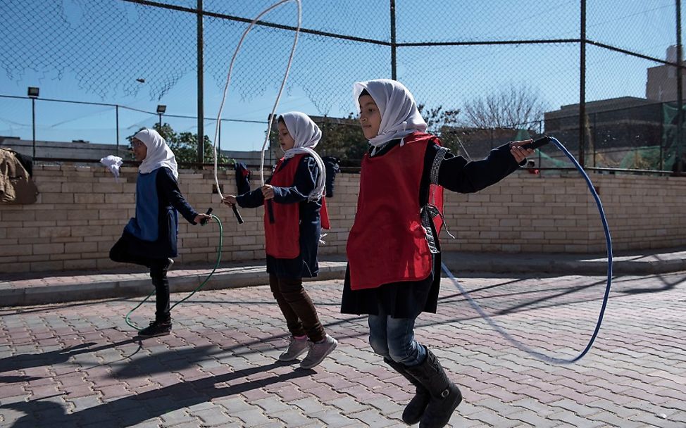 Mädchen springen Seil auf einem Schulhof in Tripolis.