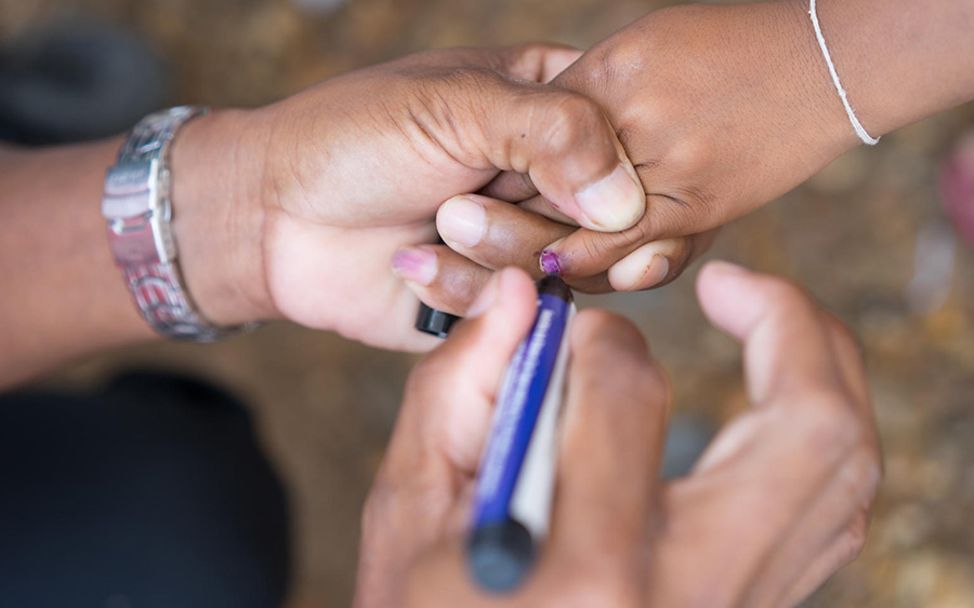 Laos: Ein Kind bekommt nach seiner Choleraimpfung eine Farbmarkierung am Finger.
