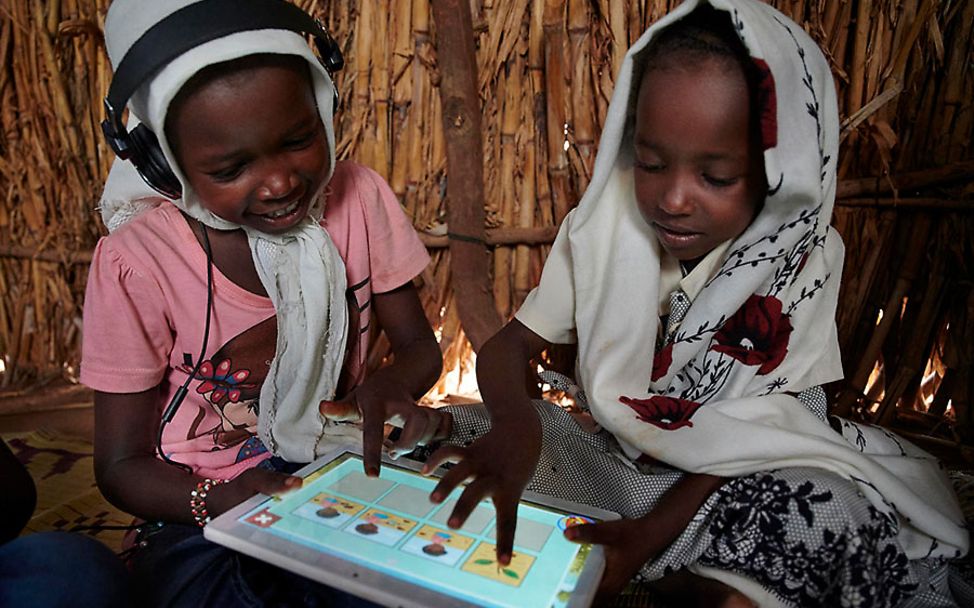 Sudan: Zwei Mädchen beschäftigen sich mit einem Lernspiel auf einem Tablet.