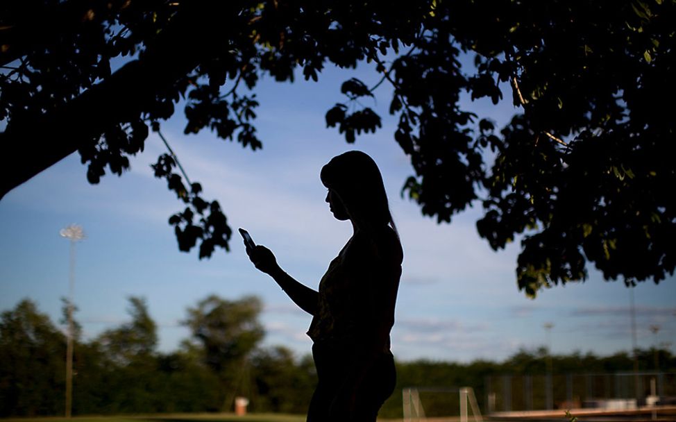 Brasilien: Schattenbild von Jessica mit ihrem Smartphone in der Hand.