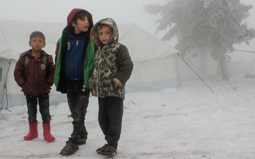 Winterhilfe Syrien: Drei Jungen stehen im Winter 2021 im Schnee in Syrien. 