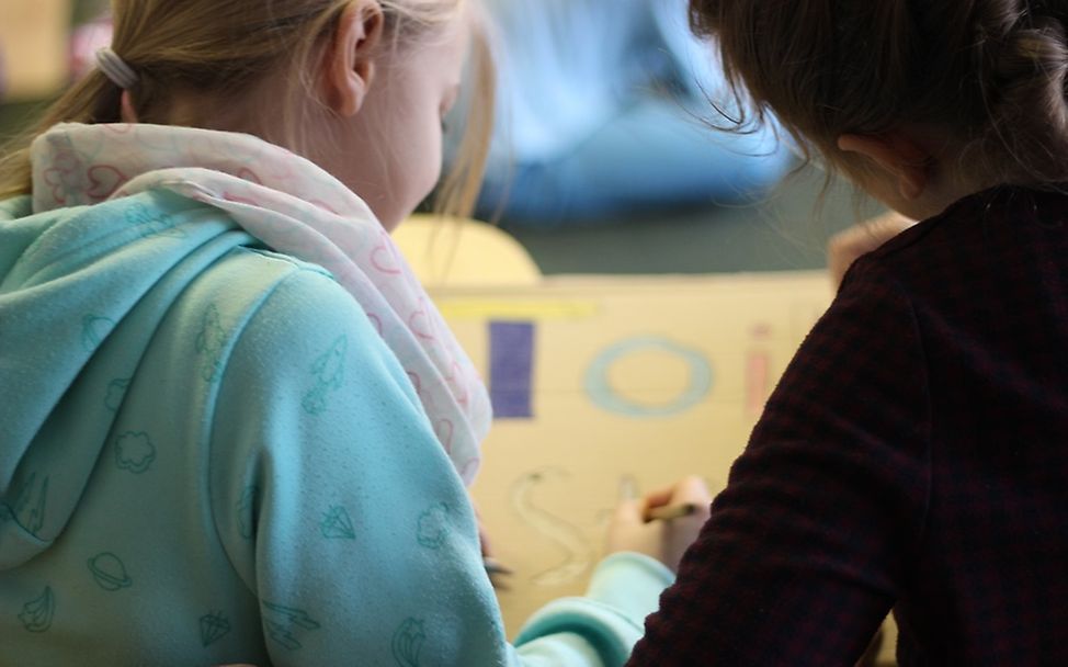 Schülerinnen malen ihre Wünsche auf Kartons © UNICEF-AG Berlin