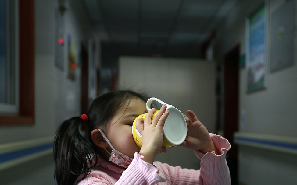 Wuhan: Ein Mädchen trinkt aus einer Tasse im Flur eines Krankenhauses.