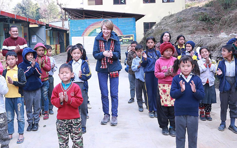 Nepal: Elke Büdenbender klatscht zusammen mit den Kindern auf dem Schulhof.