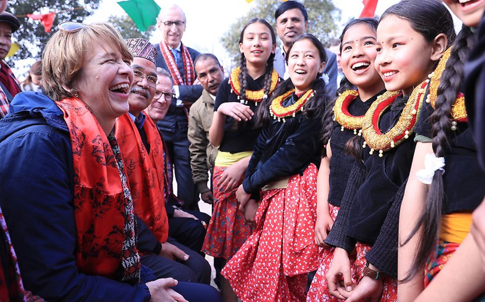 Nepal: Elke Büdenbender lacht mit Mädchen in traditioneller Kleidung. 
