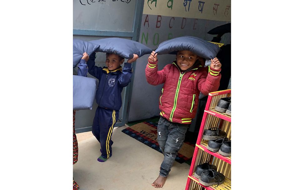 Nepal: Jungen proben mit Kissen für den Ernstfall