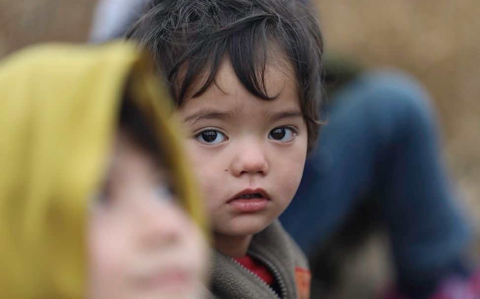 Ein Kleinkind schaut traurig an der türkisch-griechischen Grenze.