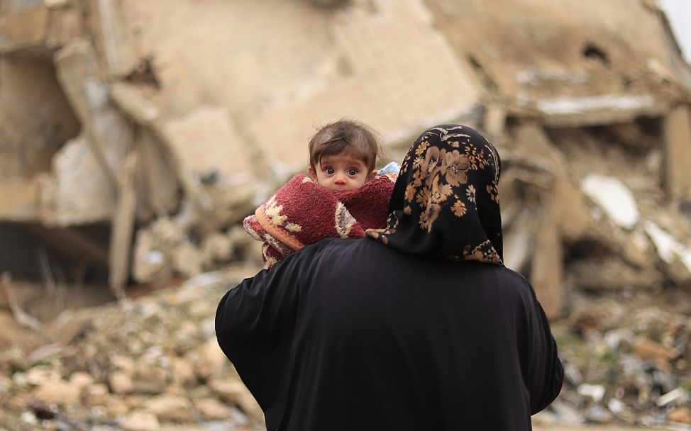 Syrien 2020: Ein Säugling schaut über die Schulter seiner Mutter.