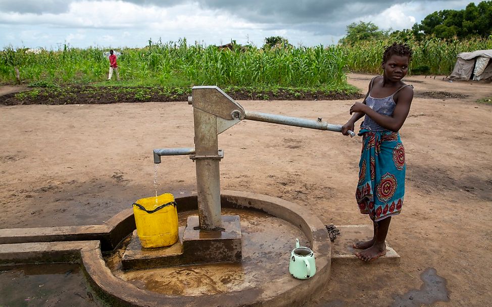 Mosambik 2020: Ein Mädchen steht an einem Brunnen.