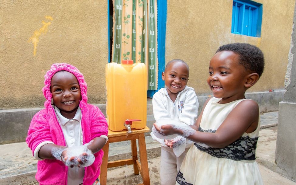 Richtig Hände waschen: Drei Mädchen waschen sich in Ruanda die Hände