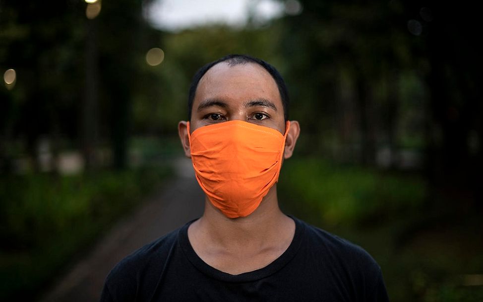 Corona-Pandemie: Ein Mann trägt einen orangenen Mundschutz.