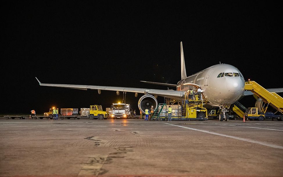 Kinshasa: Ein Flugzeug wird von Helfern bei Nacht entladen.