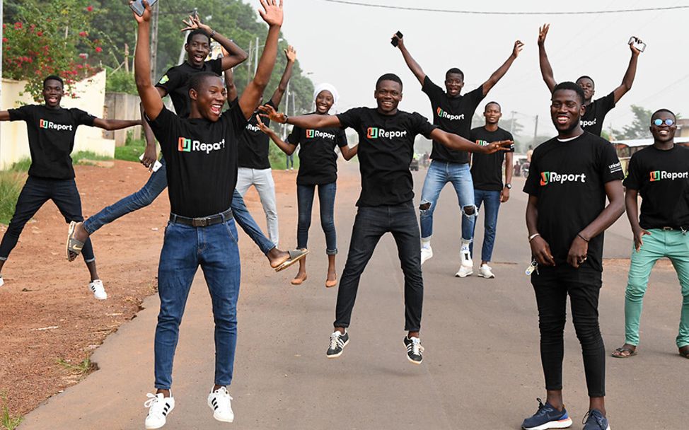 Elfenbeinküste: Jugendliche der Initiative U-Report springen lachend in die Luft.