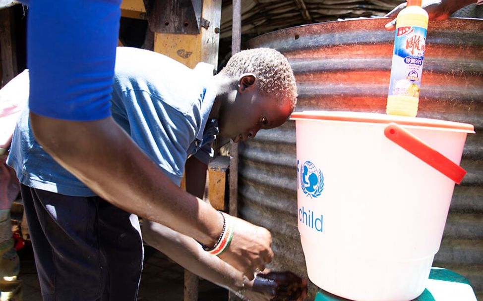 Südsudan: Ruat (10) testet mit seiner Mutter eine Handwaschstation.