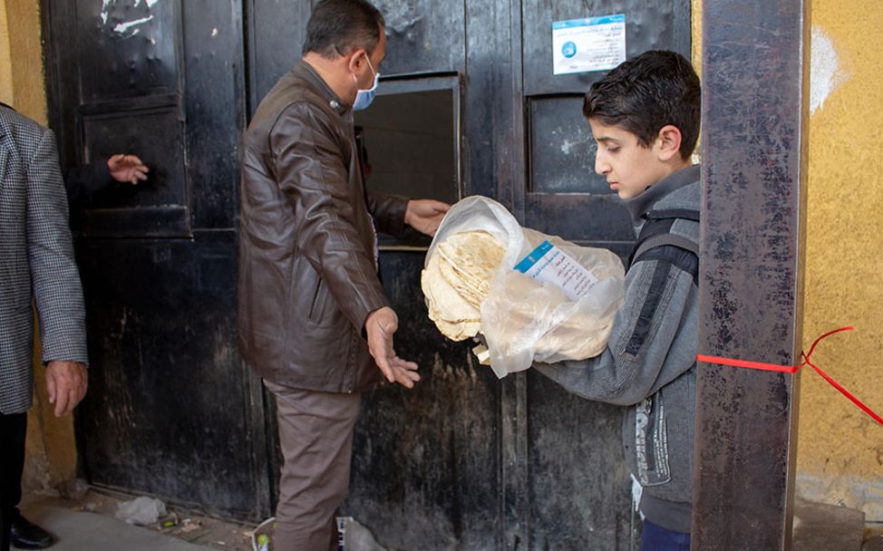 Syrien: Mohammad (11) liest die Covid-19-Informationen auf seinem Brotbeutel.