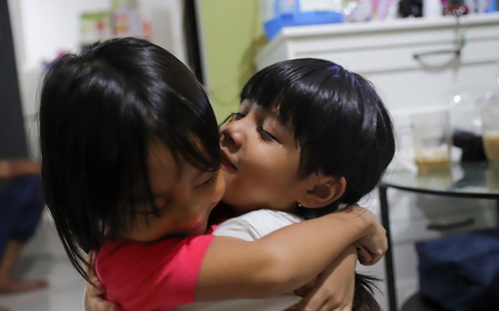 Indonesien: Zwei Schwestern umarmen sich beim Spielen.