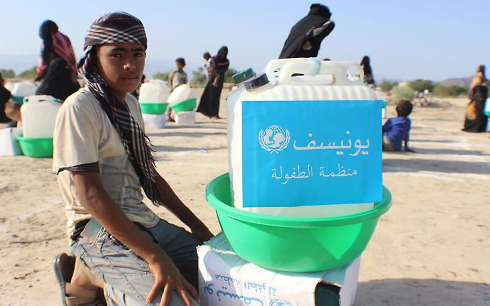 Jemen: Ein Junge bekommt Trinkwasserkanister und Hygiene-Kits