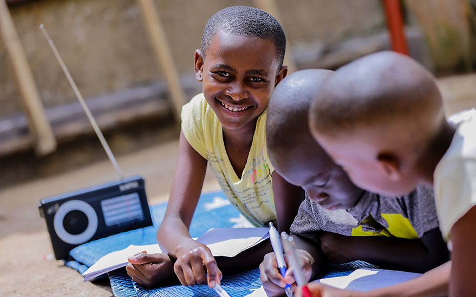 Rwanda: Umuhoza lernt mit ihren Geschwistern über das Radio für die Schule.