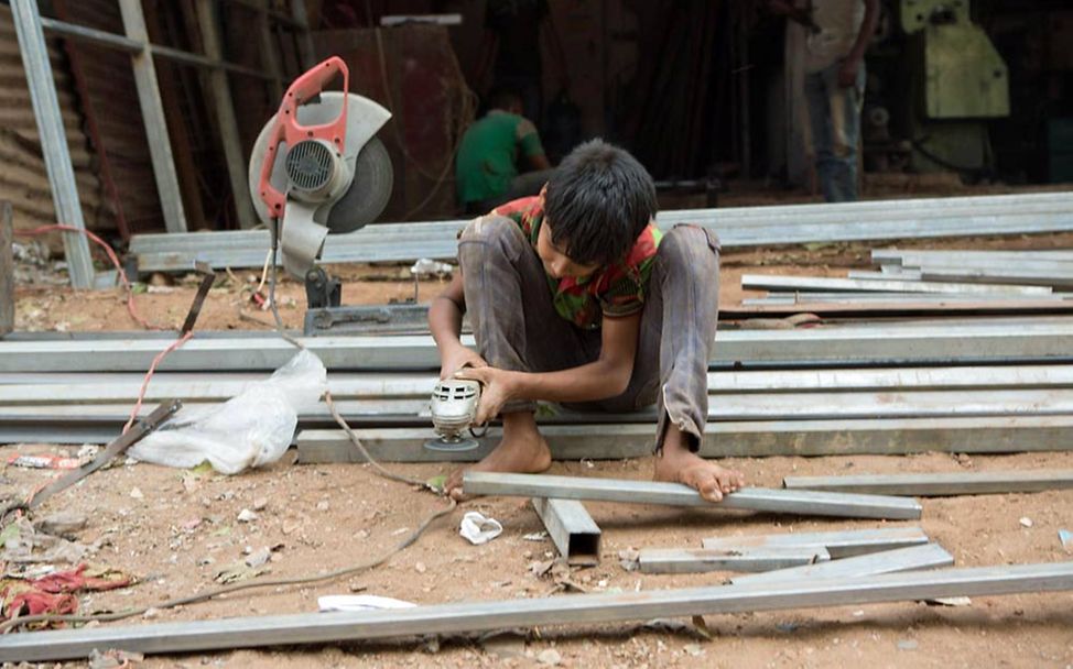 Kinderarbeit in Indien: Ein Junge arbeitet auf einer Baustelle mit einem Schleifgerät.