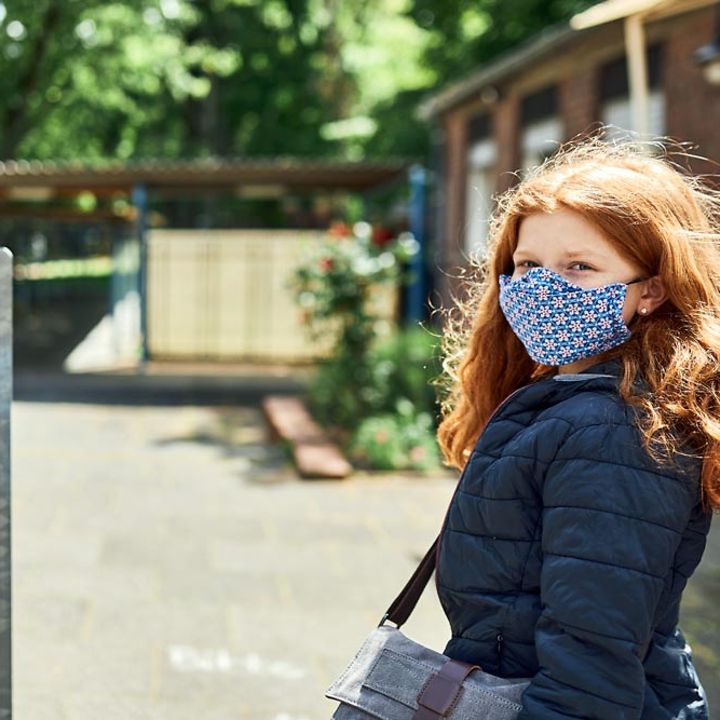 Ein Mädchen mit Corona-Atemschutzmaske. 