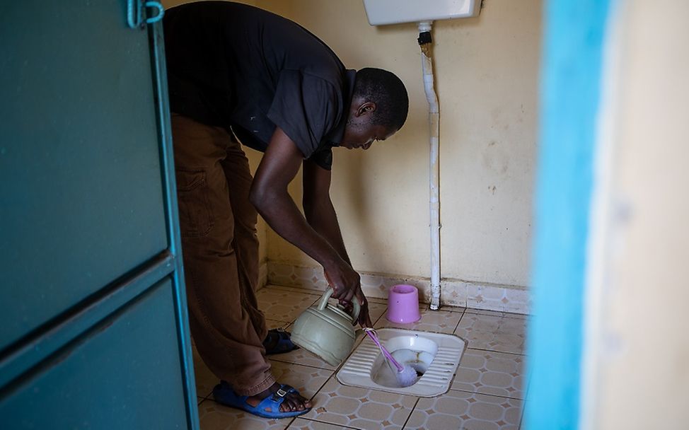Südsudan: Ein Mann säubert die sanitäre Anlage.