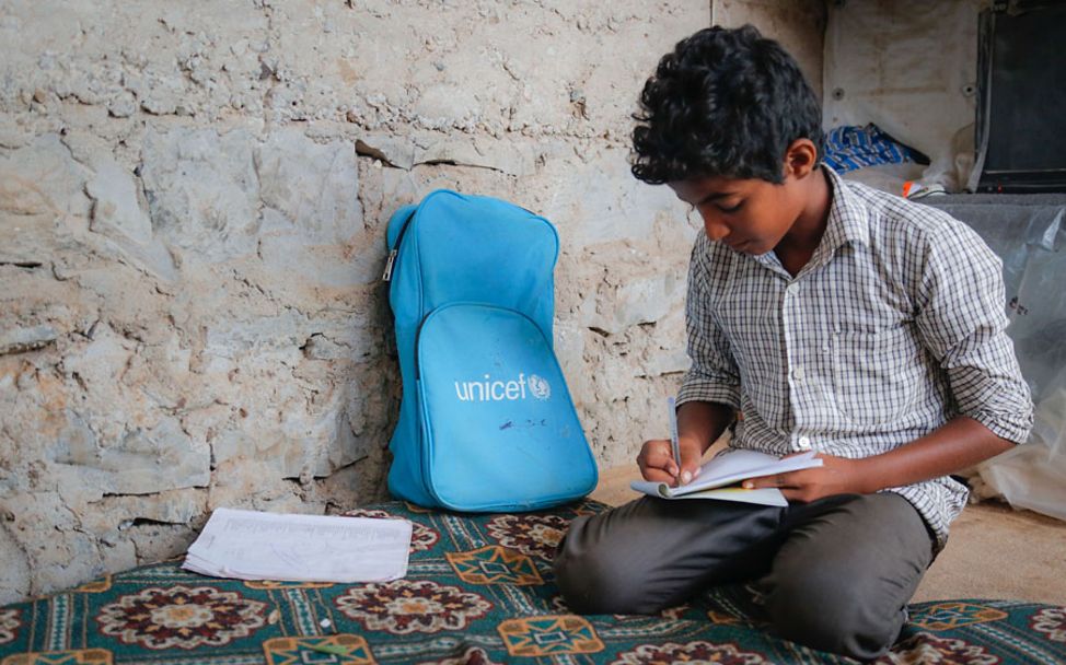 Jemen: Ein Junge hat einen Schulrucksack und anderes UNICEF-Schulmaterial erhalten.