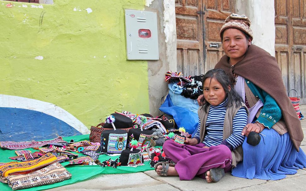 Ein Mädchen mit ihrer Mutter auf einem Markt in Bolivien
