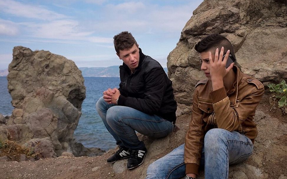 Griechenland: Zwei Flüchtlinge sitzen auf einem Felsen.