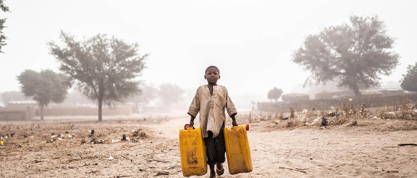 Spenden, wo es am Nötigsten ist: Ein Junge beim Wasserholen in einer trockenen Landschaft