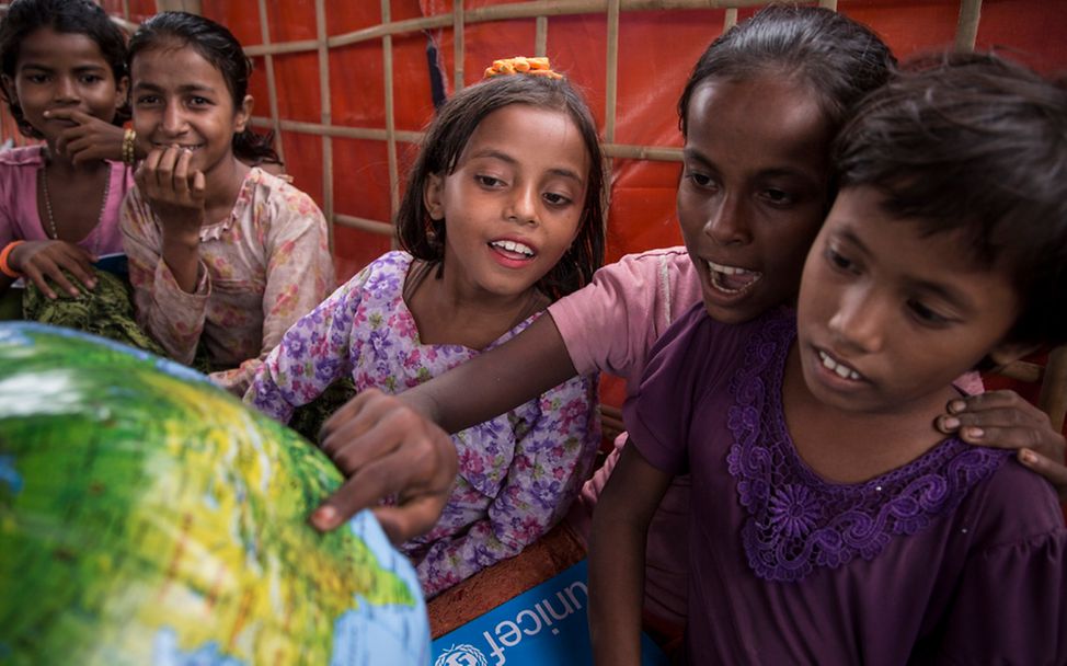 Spenden für Bildung: Rohingya-Kinder schauen sich in einem provisorischen Lernzentrum einen Globus an.