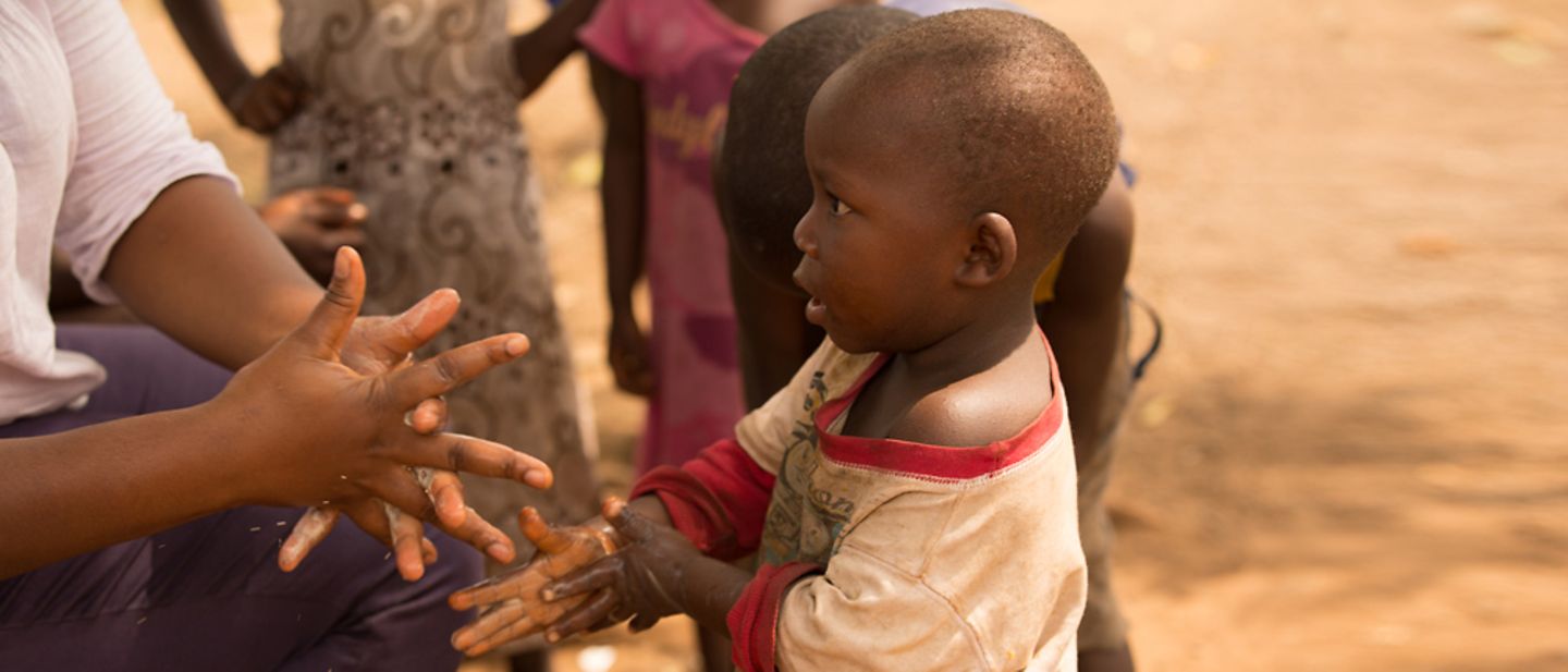 UNICEF in Guinea: Dieses Kind lernt spielerisch Händewaschen.
