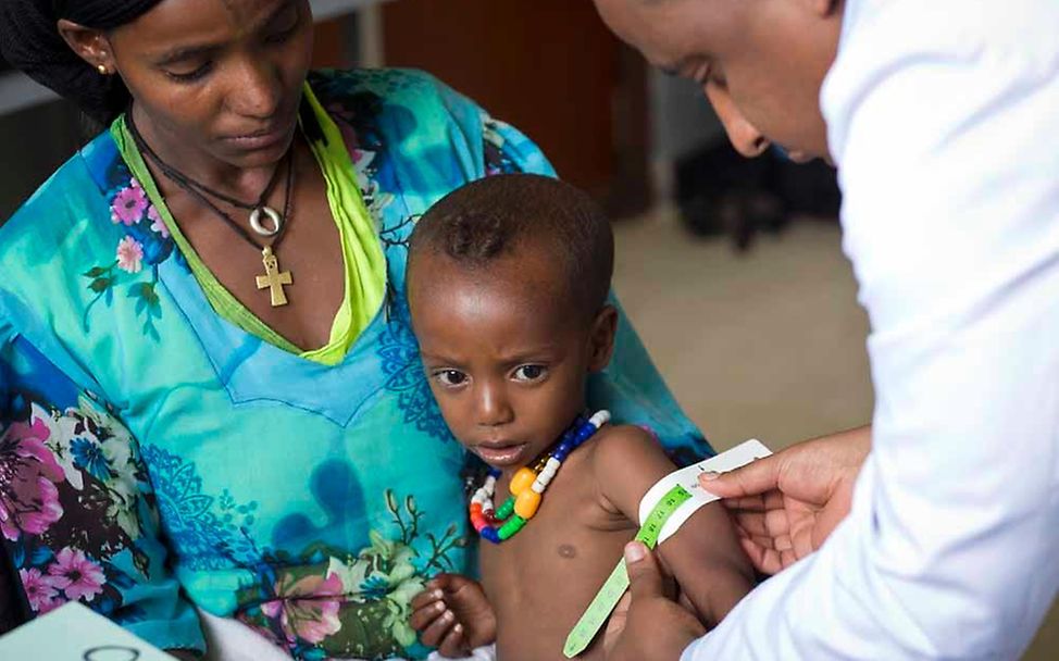 Ein Arzt misst den Armumfang eines Kindes, © UNICEF/Ose