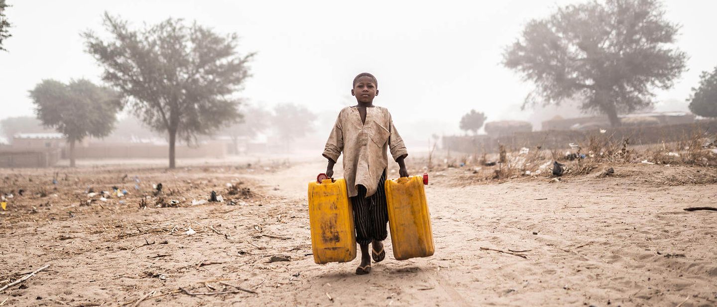 Ein Junge holt Wasser für seine Familie