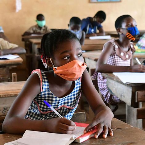 Schule während Corona: Schülerin in der Elfenbeinküste mit Maske