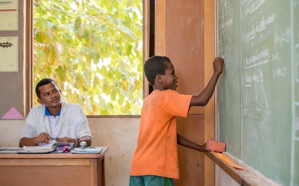 Madagaskar: Junge schreibt in der Schule an die Tafel.