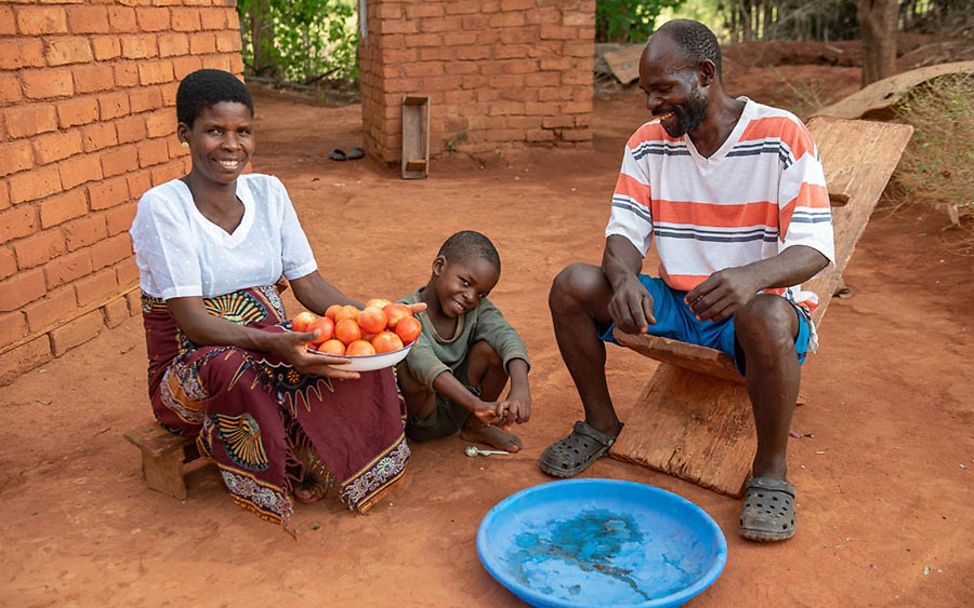 Malawi: Eine Familie zeigt ihre frisch geernteten Tomaten aus eigenem Anbau.