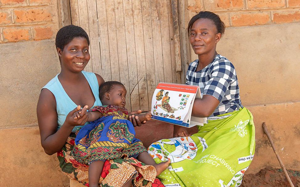 Malawi: Ganizani erklärt Elizabeth und ihrer Tochter, wie sie sich ausgewogen ernähren können.