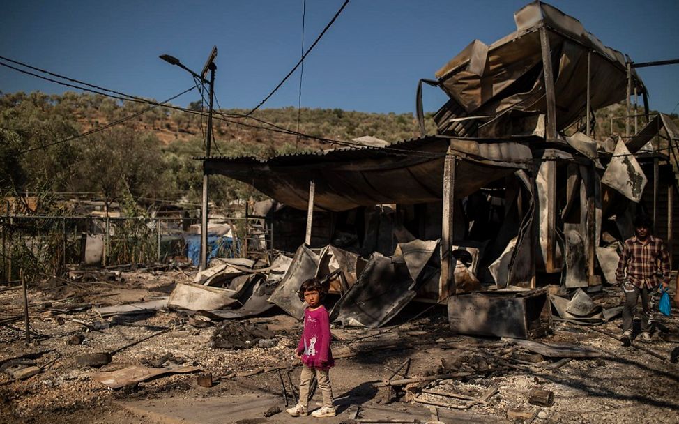 Feuer in Moria: Mädchen steht vor zerstörtem Flüchtlingslager.