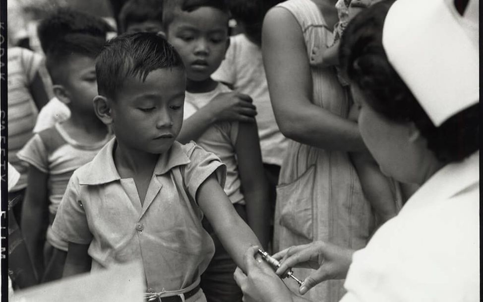 Philippinen 1952: Eine Gesundheitshelferin verabreicht Kindern eine Impfung gegen Tuberkulose.