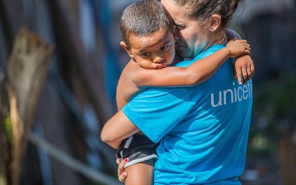 Brasilien: Eine UNICEF-Mitarbeiterin hält einen kleinen Jungen im Arm.
