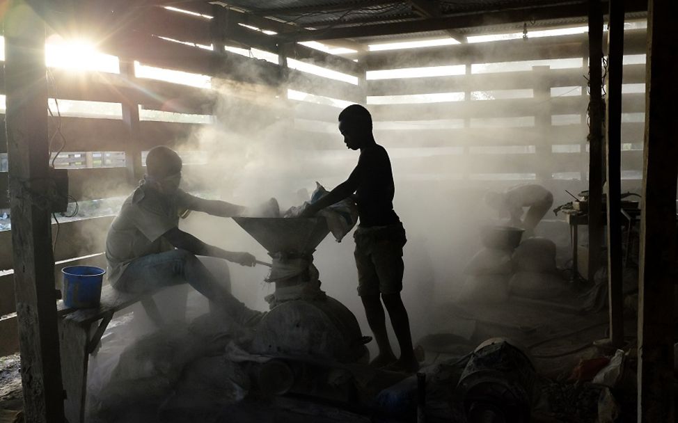 Lieferkettengesetz: Zwei Kinder arbeiten mitten in einer Staubwolke in einer Goldmine