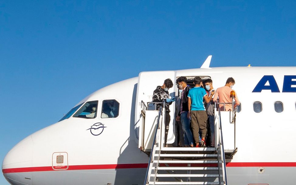Griechenland: Auf der Flugzeugtreppe stehen mehrere Jungen, die gerade in Deutschland angekommen sind.